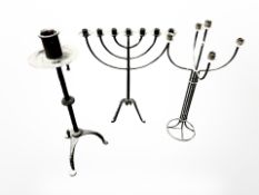 A wrought iron menorah and two similar candle stands,