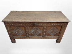 A George III panelled oak coffer with later carving,