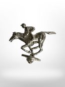 A small silver jockey on horseback