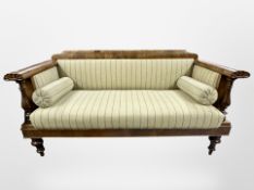 A 19th century Danish mahogany hall settee in striped upholstery with bolster cushions,