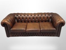 A Chesterfield brown buttoned leather three seater club settee,