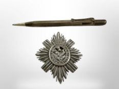 A silver propelling pencil and a Scottish badge
