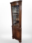A reproduction mahogany serpentine fronted corner display cabinet