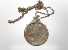 A silver coin in pendant mount