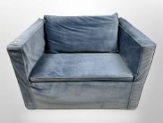 A 20th century over-sized armchair in blue upholstery,