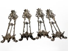 A set of four ornate cast brass easel stands,