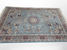 A machine made carpet of Persian Kirman design on blue ground 314 cm x 201 cm
