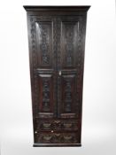 An early 19th century carved oak double door cabinet,
