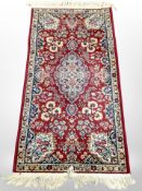 A machine made rug of Persian design 155 cm x 74 cm