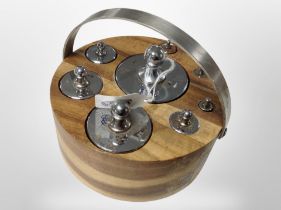 A circular wooden stand containing a set of graduated chrome weights ranging from 2lb to a 1/4oz.