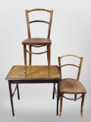 An Edwardian oak table and two bentwood chairs