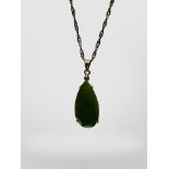 A cut pear-shaped green hardstone pendant on silver gilt chain