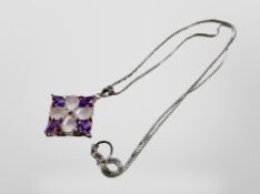 A silver pendant on chain set with pink and amethyst coloured stones