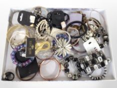 A shallow tray containing mixed costume jewellery, bangles, etc.