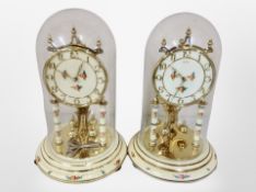 Two Kundo clocks under glass domes