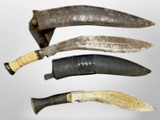 Two Nepalese kukri knives in sheathes.