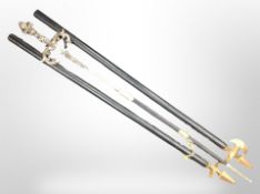 A decorative sword in scabbard and two brass-tipped staffs.