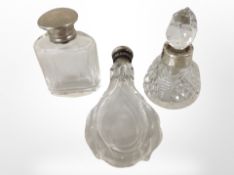 Three silver-topped scent bottles.