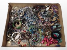 A shallow tray containing a large quantity of costume jewellery, bangles, etc.