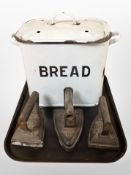 A vintage enamelled bread bin and three flat irons.