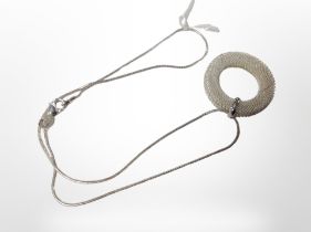 A silver halo pendant on chain.