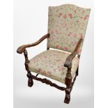 A carved oak framed armchair in Arts and Crafts style upholstery,