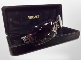 A pair of Versace sunglasses in box.