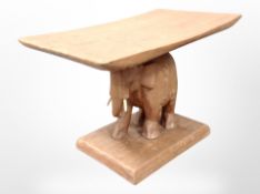 A low hardwood table on elephant support,