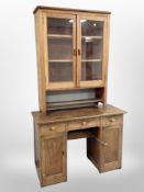 An Edwardian oak twin pedestal desk and a glazed bookcase