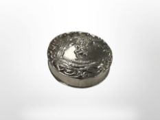A small circular embossed silver pillbox, diameter 3.5 cm.