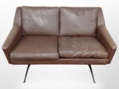 A late 20th century Danish brown leather two seater settee, on chrome supports,