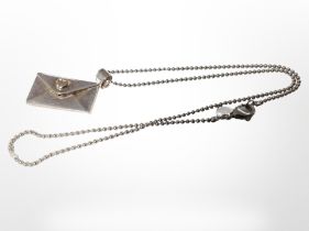 A silver envelope pendant on chain.