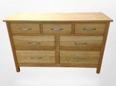 A contemporary solid oak seven drawer low chest,