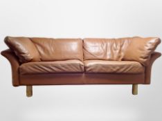 A late 20th century Danish tan leather three seater settee,
