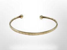 A 9ct gold bangle, inner diameter 6cm. CONDITION REPORT: 4.4g. With steel core.