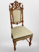 A 19th century heavily carved beech hall chair with armorial crest flanked by two dragons