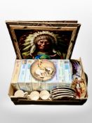 A box of Native American pictures, collectors plates, and puzzles.