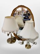 A gilt framed oval mirror and two contemporary table lamps