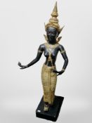 A Thai gilt and ebonised semi nude figure on wooden plinth,