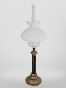 An oil lamp with opaque glass shade, height 79cm.