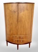 A 20th century Danish teak bow fronted corner cabinet,
