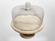 A turned wooden cake stand with glass dome cover, height 36cm.