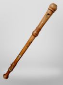An oversized turned wooden recorder,