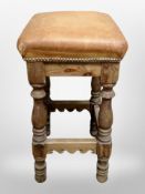 A tan leather topped oak stool