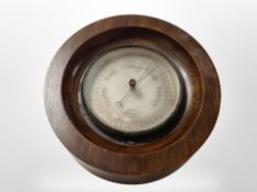 A circular barometer with silvered dial, diameter 22cm.
