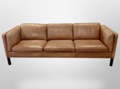 A late 20th century tan leather three-seater settee,