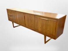 A teak low cocktail sideboard fitted cupboards and drawers,