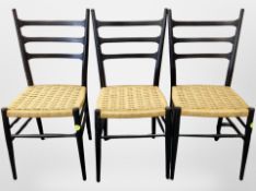 A set of three Scandinavian ebonised ladder backed chairs with rattan seats