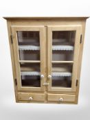An early 20th century glazed pine wall cabinet,