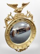 A Regency style gilt wood and gesso circular convex mirror with eagle pediment,